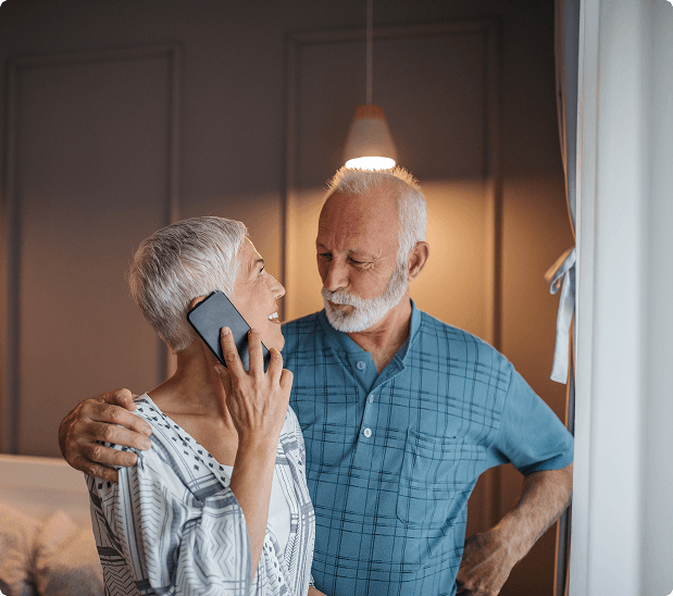 An older woman smiling during a friendly phone call at home